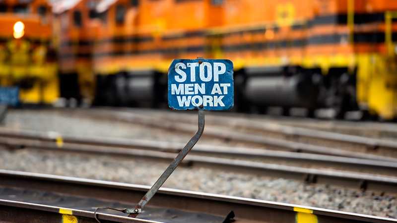 A small blue sign that says 'Stop Men at Work'.